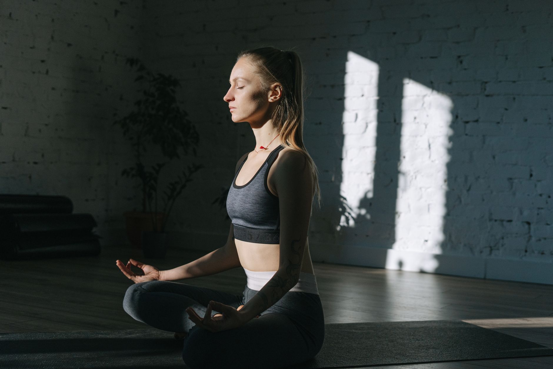 Frau in stiller Meditation im weichen Licht — der Moment, in dem der Griff sich löst