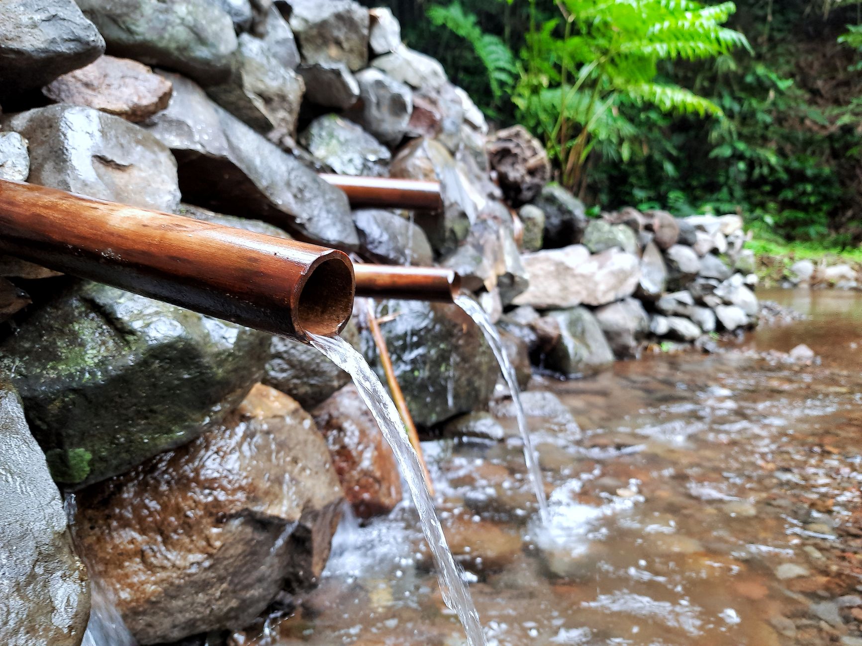 Wasser, das ruhig über glatte Steine fließt — das alte Bild des Loslassens